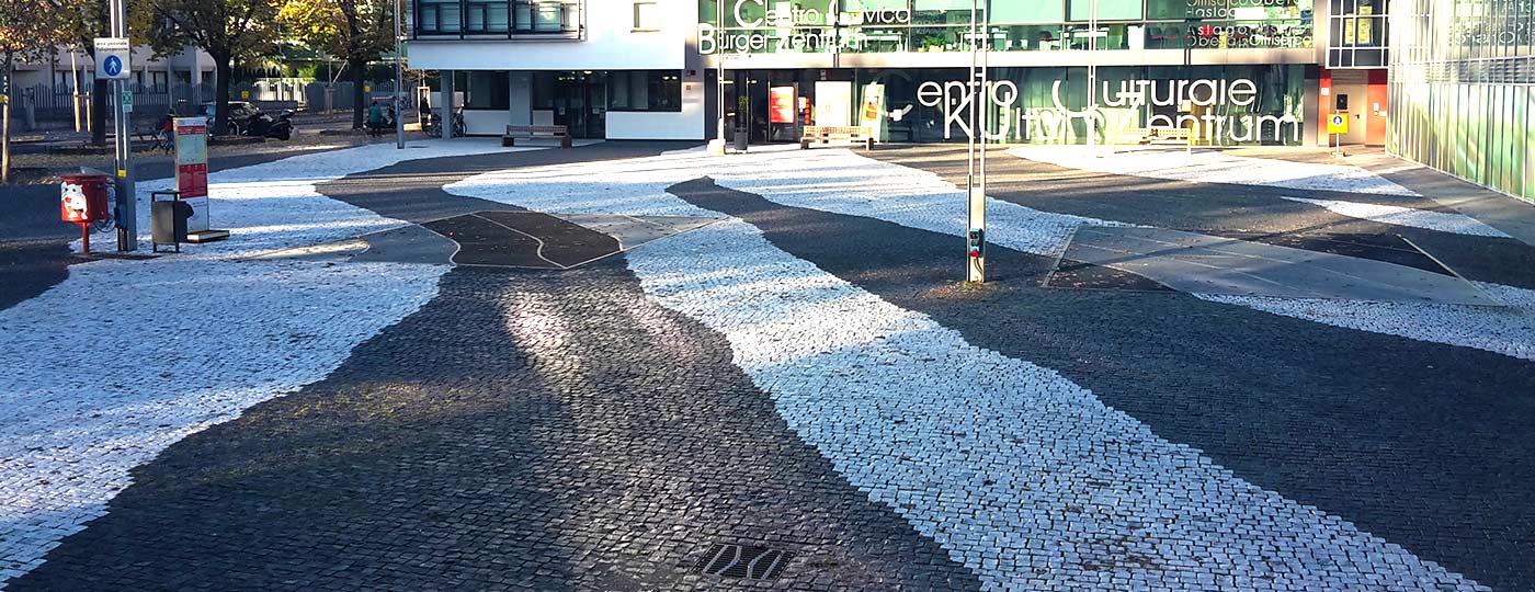 Piazzale pavimentato da Stone Concept con cubetti di porfido bianchi e neri che creano percorsi e disegni sul terreno